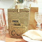 braune Wundertüte mit schwarzer Musterung gezackt. Bedruckt mit der Schrift "Friede Freude, Eierkuchen" und drei Eiern