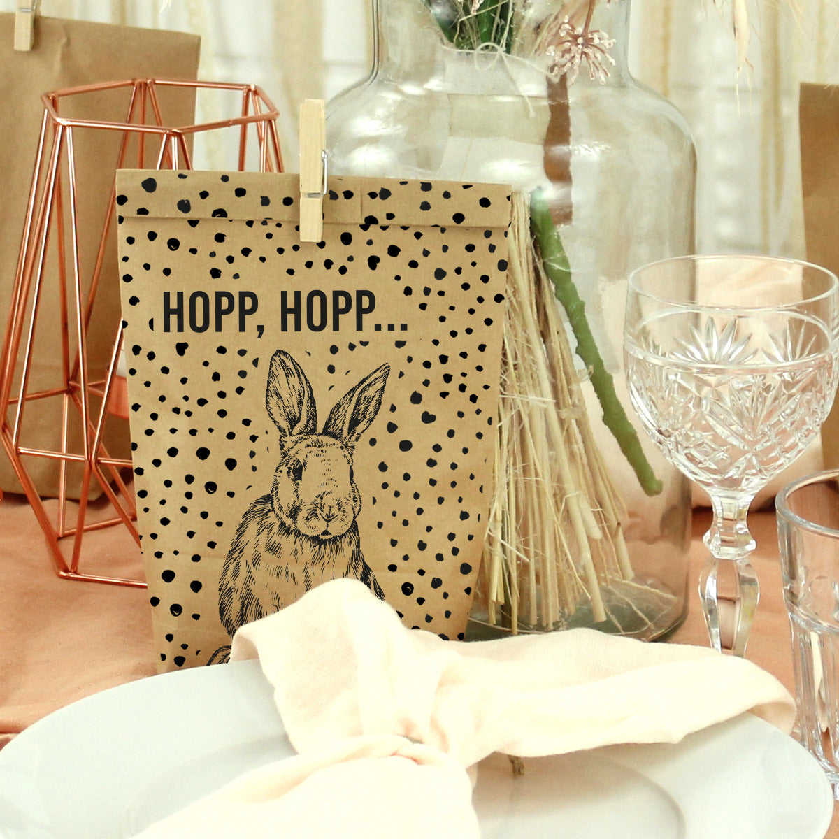 braune Wundertüte mit schwarzer Musterung gepunktet. Bedruckt mit der Schrift "hopp, hopp" und einem Hasen