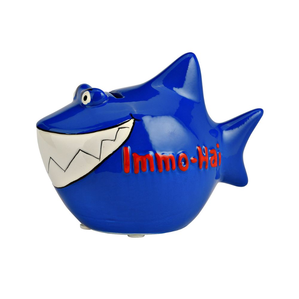 Dunkelblauer Hai, Sparschwein aus Keramik in Hai Form mit Hai Flossen, großes Weißes Gebiss, lustige 3D Augen, rote 3D Aufschrift auf der Seite: Immo-Hai, von der rechten Seite fotografiert