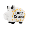 Weißes Sparschwein mit schwarzen Füßen und Ohren und der Schrift "Luxus Schwein" Die Schrift ist umgeben mit goldenen ovalen Formen