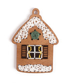 Nahaufnahme des Holz Lebkuchenhaus Schmuckstücks bestickt mit gelbem grünem und weißem Garn