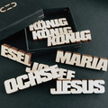 Dekoration aus Holz Naturfarben in Form einiger Wörter im Zusammenhang mit der Krippe: "König", "Maria", "Esel", "Ochse", "Josef", "Jesus"