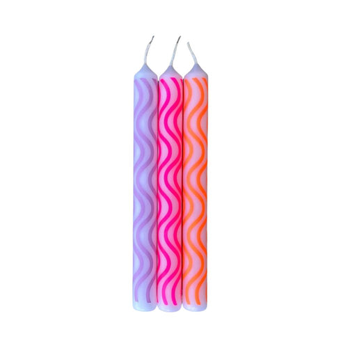 Drei Stabkerzen in der Farbe lila mit Wellen Muster in den Farben Dunkellila, Pink und Orange