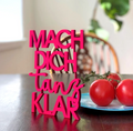 Wanddekoration aus Holz gefärbt in Neon Pink in Form einer Schrift "Mach dich tanz klar"