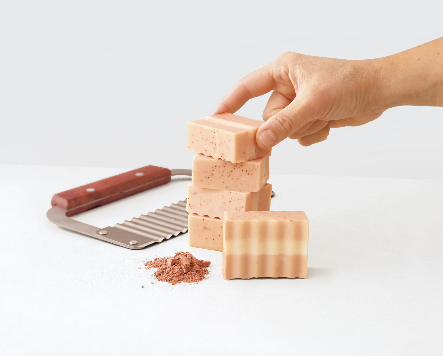 Die fertige Seife wird von einer Hand gestapelt