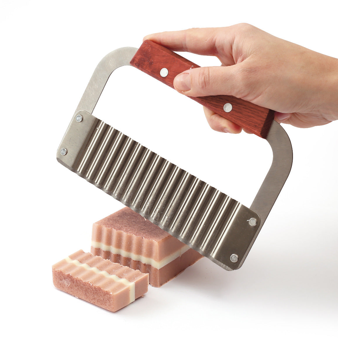 Seife wird von einem welligen Messer geschnitten