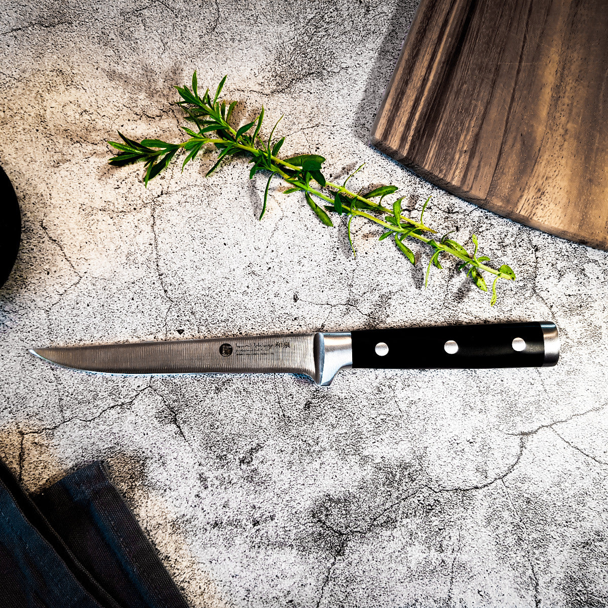 Das Messer auf der Küchenplatte mit Kräuter und Schneidebrett