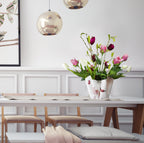 Die Faltvase mit Weiß/Pinkes Flamingo Design, innenseite rot gefärbt, zusammengehalten mit einem weißen Band auf einem Tisch mit Blumen innendrin