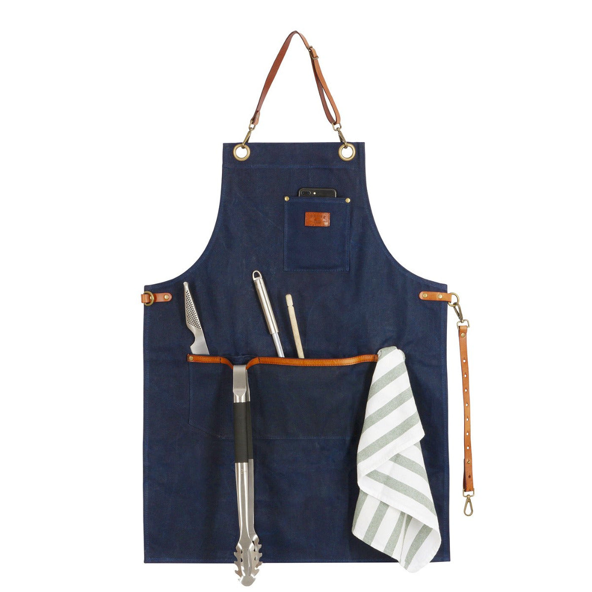 Grillschürze in Navy Blau mit Lederträger und befestigungs Bänder in dessen Taschen verschiedene Grill-utensilien und ein Handtuch verstaut sind