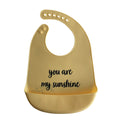 Gelbes Silikon Lätzchen mit einer aufgedruckten schwarzen Schrift "You are my Sunshine" und einer Auffangschale