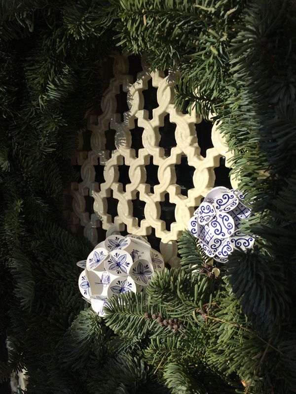 Weinachtskugeln mit einem Delfterblauen Keramik Design, aus Papier zusammengesteckt hängen an an einem Tannen-Kranz