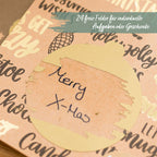 Eine aufgerubbelte Karte mit der dahiner aufgedeckten Schrift "Merry X-Mas"