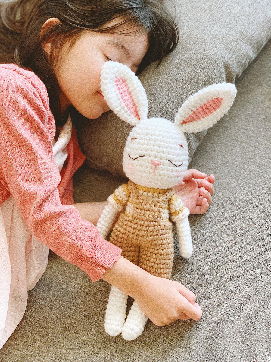 ein Kind schläft zusammen mit dem Kaninchen Plüschtier