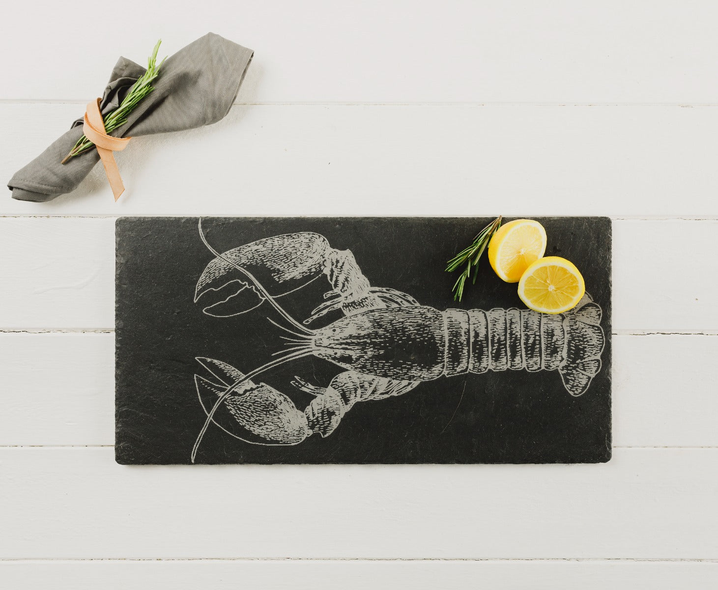 Eine rechteckige Servierplatte aus Schiefer mit einem eingravierten Hummer-Motiv
