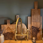 Ein Eichen Servierbrett mit einem eingebranntem "Hochlandrind" Design auf einem Tisch mit anderen Brettern