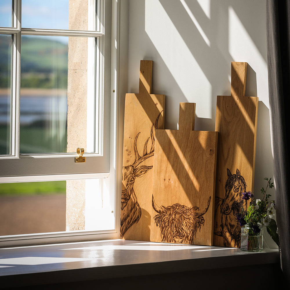 Eichen Servierbrett mit eingebrannten Hochlandrind Muster an einer Wand auf der Fensterbank angelehnt