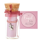 In einer kleinen Glasphiole mit Korkverschluss befindet sich ein Pinkes Armband mit einem kleinen Engel Symbol, dass um einer pinken Rolle umwickelt ist. Mit einer an der Phiole angebundenen Karte auf der steht "Ein Engel für ALLTAG!"