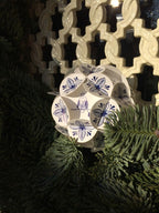 Nahaufnahme der Weinachtskugel mit einem Delfterblauen Keramik Design, aus Papier zusammengesteckt in einem Kranz