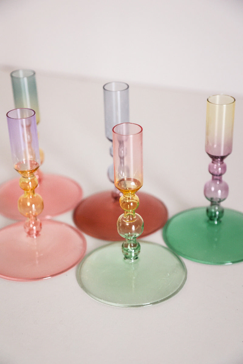 Verschieden farbige Kerzenhalter aus Glas auf einem Tisch