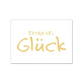 Weiße Postkarte mit der Goldenen Schrift "Extra viel Glück"