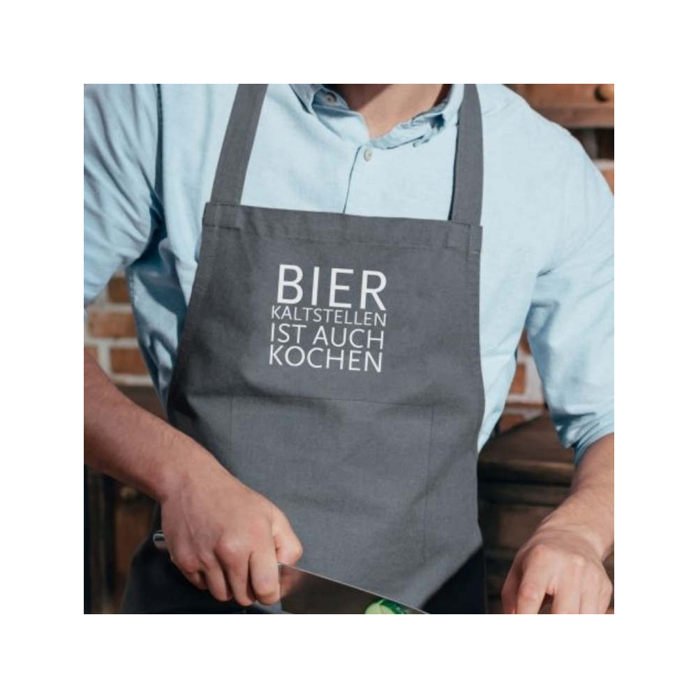 Eine Schürtze mit dem weißen Print ''Bier kaltstellen ist auch kochen'' von 17;30