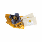 Nachhaltige Bienenwachstücher in Gelb und Blau, mit Mohnbällchen und der Verpackung