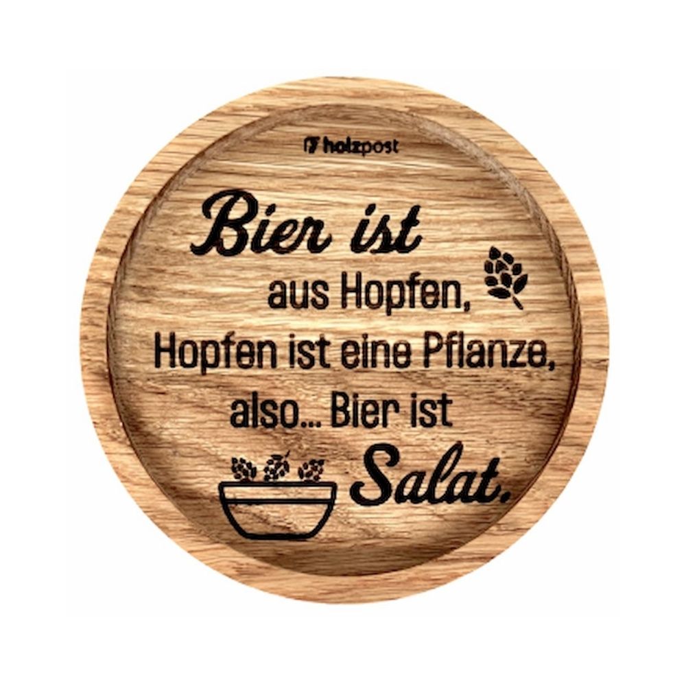 Eingekerbter Holzuntersetzer mit dem aufgedruckten Spruch „Bier ist aus Hopfen, Hopfen ist eine Pflanze, also... Bier ist Salat" Mit einer Kleinen Salatschüssel in der Hopfen liegen