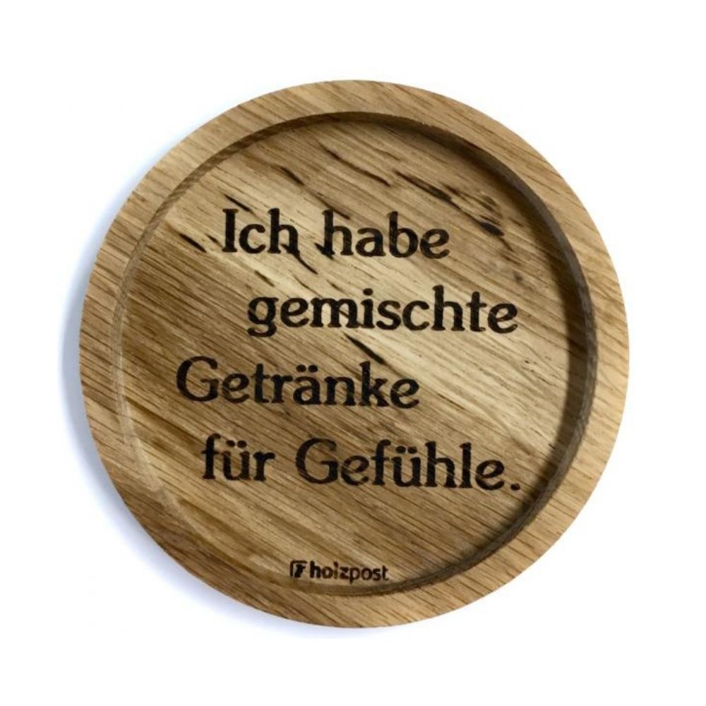Eingekerbter Holzuntersetzer mit dem aufgedruckten Spruch „Ich habe gemischte Getränke für Gefühle."