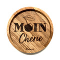 Eingekerbter Holzuntersetzer mit dem aufgedruckten Spruch „Moin Cherie"