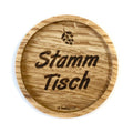 Eingekerbter Holzuntersetzer mit dem aufgedruckten Spruch „Stamm Tisch" und einem kleinen aufgedruckten Hopfen oben mittig