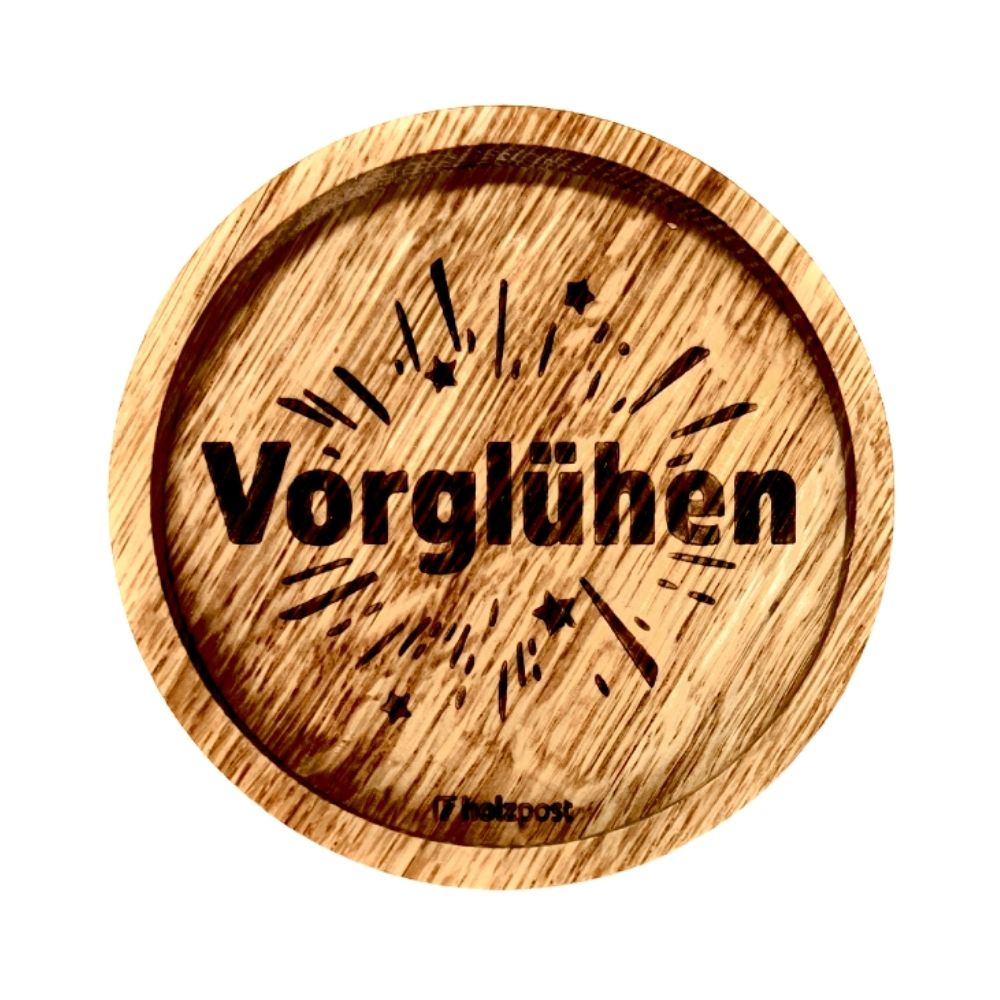 Eingekerbter Holzuntersetzer mit dem aufgedruckten Spruch „Vorglühen"