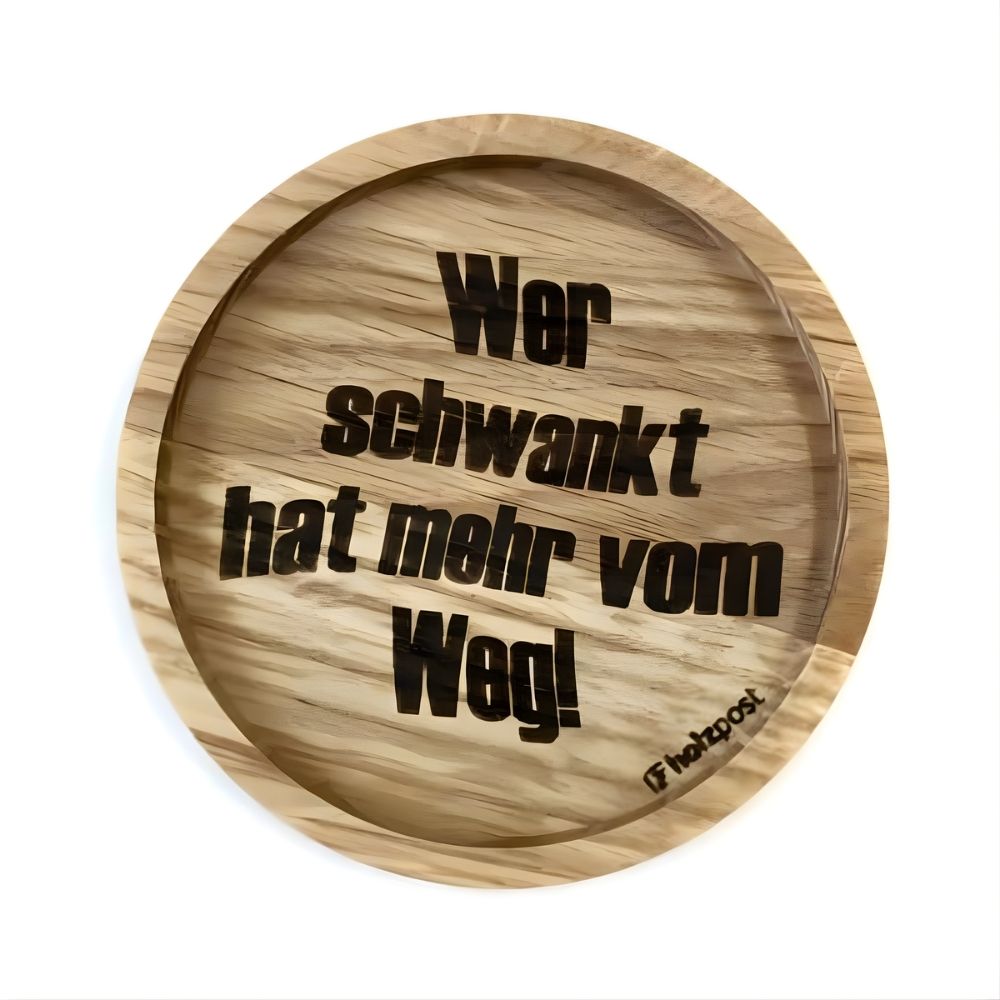 Eingekerbter Holzuntersetzer mit dem aufgedruckten Spruch „Wer schwankt hat mehr vom Weg"