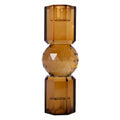 Ein hoher wendbarer Kerzenhalter aus Glas in Goldbraun Kristall-Optik, bestehend aus mehreren geometrischen Flächen. Der Kerzenhalter hat eine moderne, facettierte Optik, die das Licht reflektiert