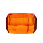 Ein kleiner Dioptrics Kerzenhalter aus Glas in Bernstein Kristall-Optik, bestehend aus mehreren geometrischen Flächen. Der Kerzenhalter hat eine moderne, facettierte Optik, die das Licht reflektiert