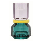 Ein hoher wendbarer Dioptrics Kerzenhalter aus Glas in Violett, Gelb und Petrol Kristall-Optik, bestehend aus mehreren geometrischen Flächen. Der Kerzenhalter hat eine moderne, facettierte Optik, die das Licht reflektiert, gewendet