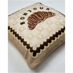 nahaufnahme des Kissens mit Croissant und der Schrift "BONJOUR"