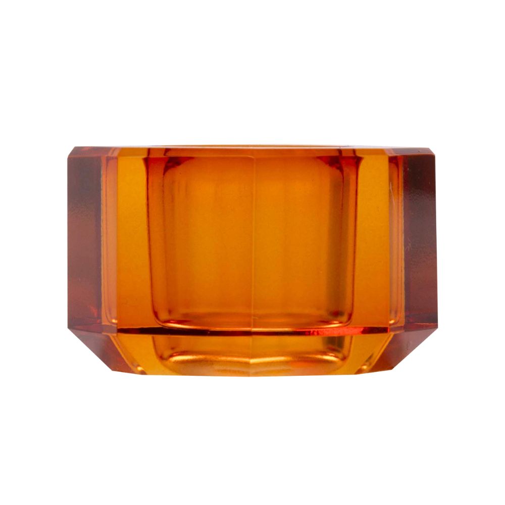 Ein kleiner Kerzenhalter aus Glas in Bernstein Kristall-Optik, bestehend aus mehreren geometrischen Flächen. Der Kerzenhalter hat eine moderne, facettierte Optik, die das Licht reflektiert
