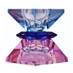 Ein hoher wendbarer Kerzenhalter aus Glas in Violett, Braun und Kobalt Kristall-Optik, bestehend aus mehreren geometrischen Flächen. Der Kerzenhalter hat eine moderne, facettierte Optik, die das Licht reflektiert