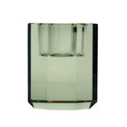 Ein niedriger Kerzenhalter in Olive Kristall-Optik, bestehend aus mehreren geometrischen Flächen. Der Kerzenhalter hat eine moderne, facettierte Optik, die das Licht reflektiert