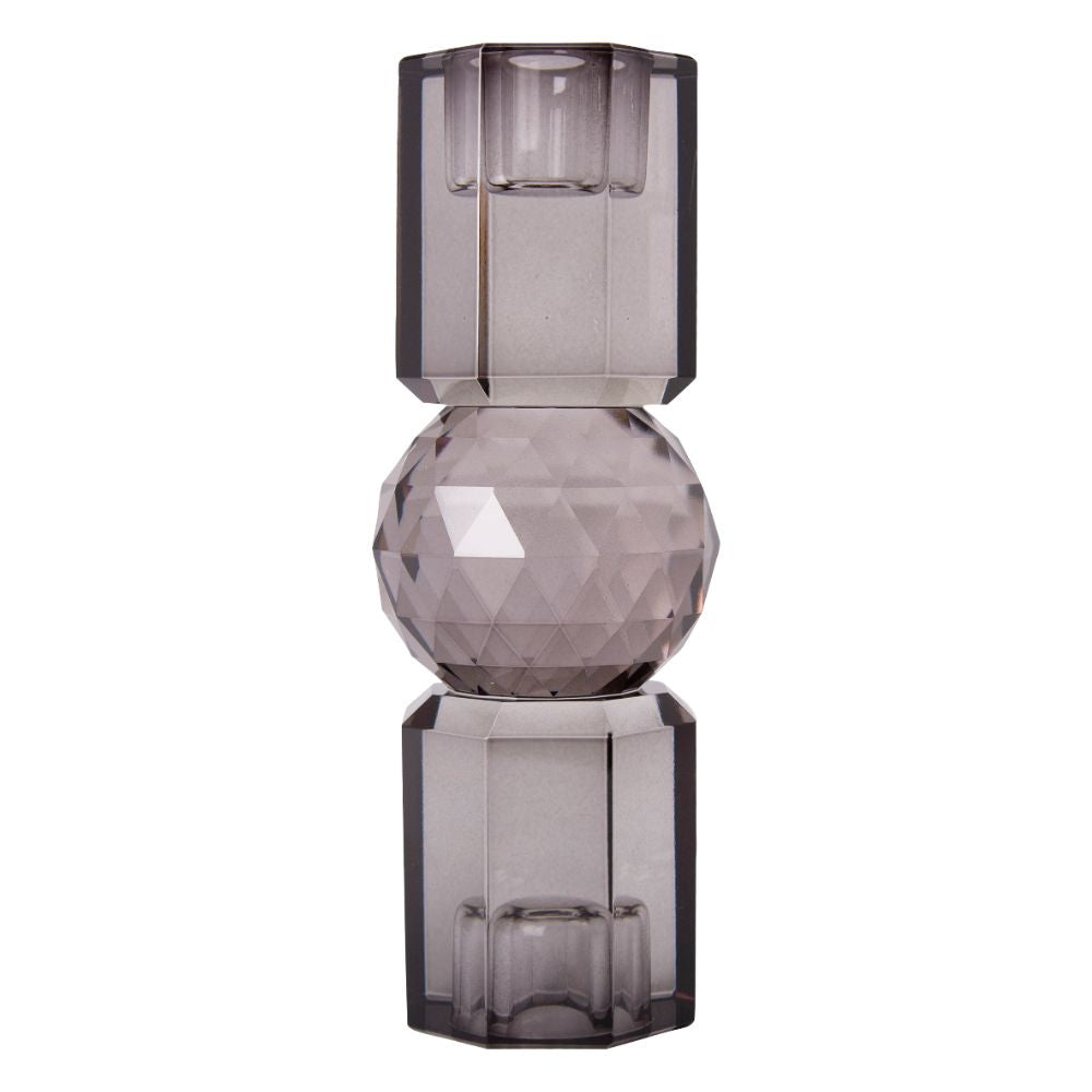 Ein kleiner wendbarer Kerzenhalter aus Glas in Rauchgrauer Kristall-Optik, bestehend aus mehreren geometrischen Flächen. Der Kerzenhalter hat eine moderne, facettierte Optik, die das Licht reflektiert.