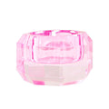 Ein kleiner Dioptrics Kerzenhalter aus Glas in Pink Kristall-Optik, bestehend aus mehreren geometrischen Flächen. Der Kerzenhalter hat eine moderne, facettierte Optik, die das Licht reflektiert