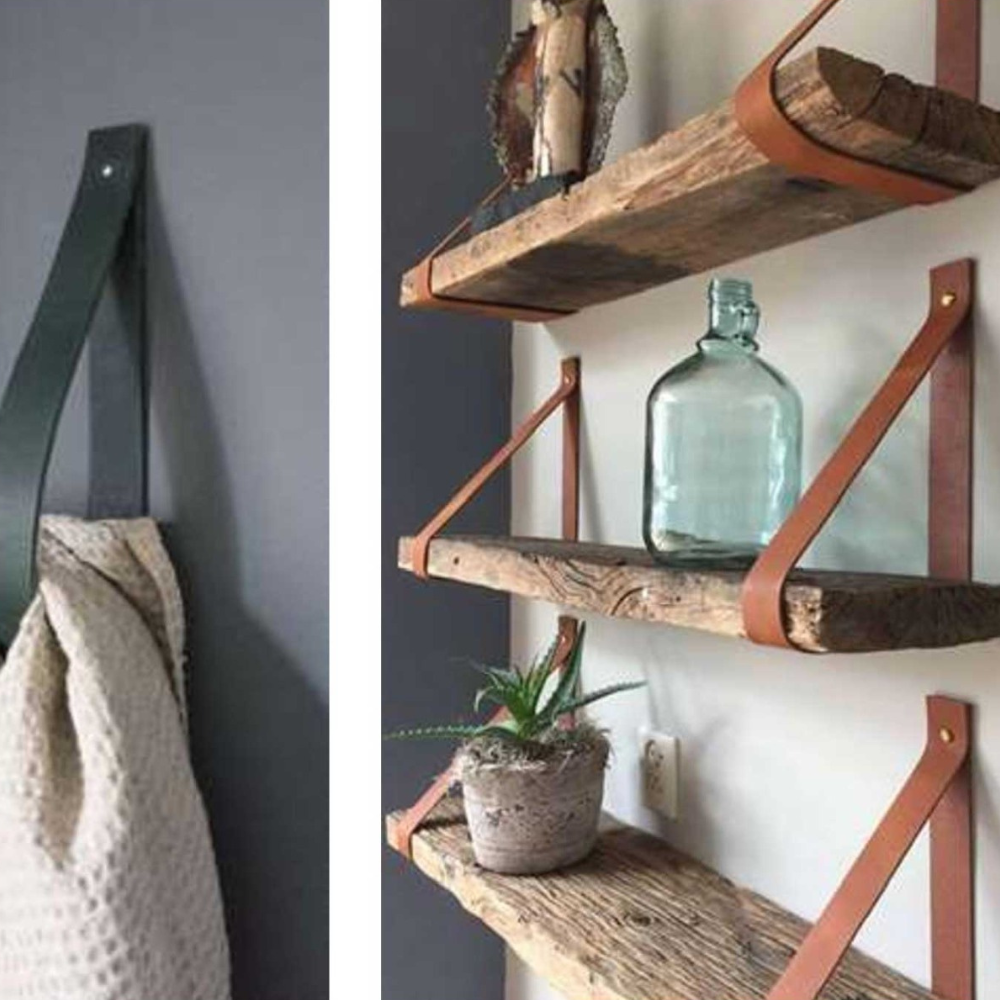 Ein Regalhalter aus Cognac Leder, indem ein Handtuch eingehanden ist oder wodurch ganze Holzbretter an der Wand zur ablage hängen