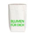Eine weiße Papiertüte aus Starkpapier mit einem grünen Schrift Aufdruck "BLUMEN FÜR DICH" 
