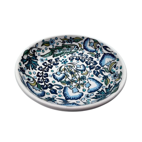 Weiße Keramikschale mit aufgemaltem Blumenmuster in blau, lila  und grün Tönen, Schale mit 20 cm Durchmesser, schräg von der Seite fotografiert