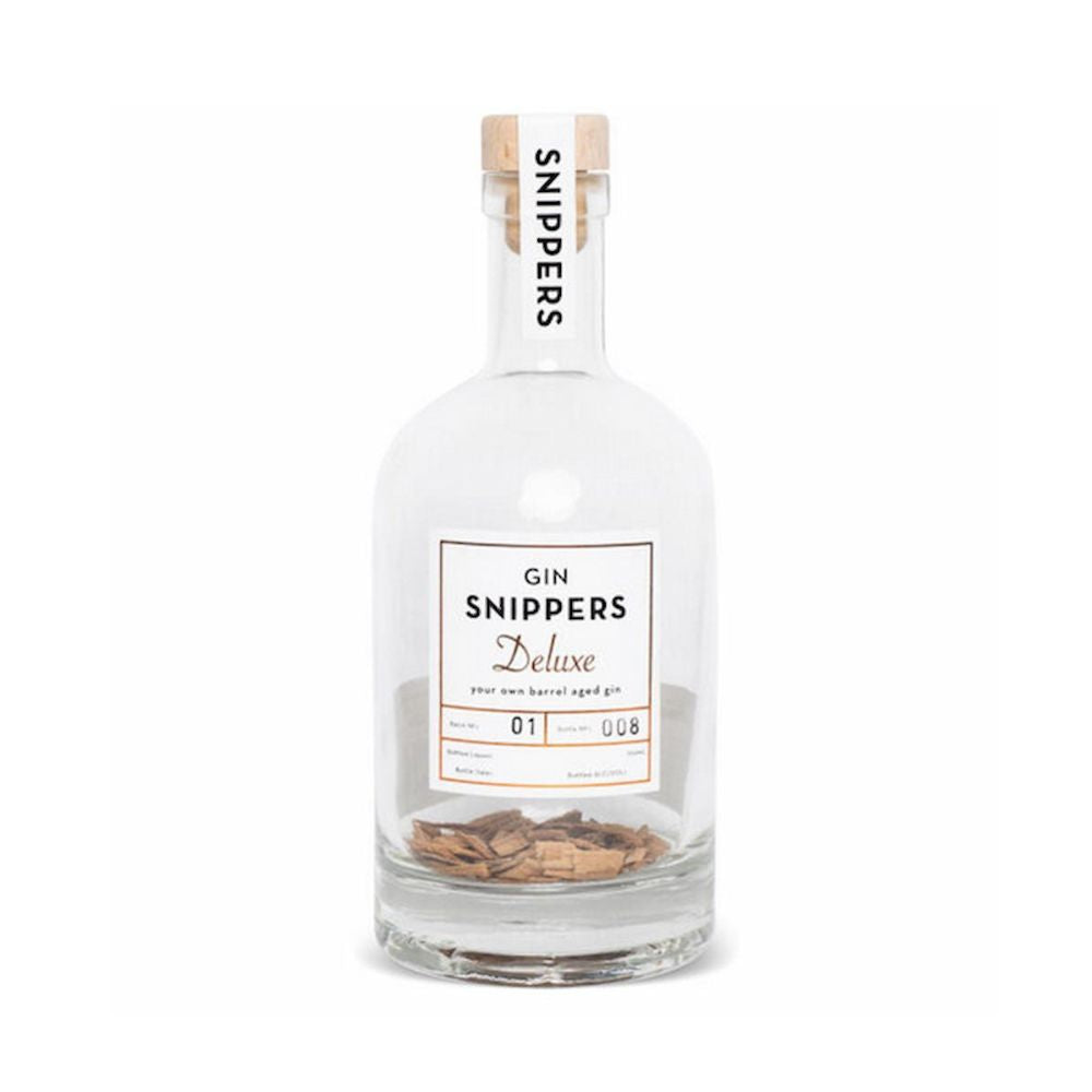 Eine mit Holzschnipsel von alten schottischen Fässern gefüllte, sonst leere GIN-Flasche mit Kork-Verschluss mit der Aufschrift "GIN SNIPPERS Deluxe"