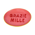 Runder Teller in Pink mit gelbem Rand und einer Roten schrift "GRAZIE MILLE"