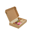 Eine Schachten in der eine Korken-Phiole liegt in der sich verschiedene getrocknete Blumen befinden mit einem Holz-Ständer für die Phiole