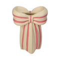 Vase aus Polyresin in Form einer großen Schleife, Grundfarbe ist Beige, auf der Schleife sind rosane Streifen als Highlights, große 3D Geschenkschleife als Deko Vase