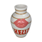 Vase in Oval Form gestreift in Weiß und Braun mit einer haptischen Lippen-Form in Rosa und einer Schrift "HELLO"