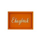 Rechteckige orangene Wanddekoration mit der Schrift "Eheglück"